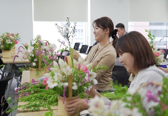 22일 서울 종로구 흥국생명 본사 사옥에서 흥국생명 임직원들이 미혼모가정에게 선물할 꽃바구니를 제작하고 있다 [사진=흥국생명]