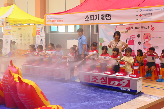이달 강원지역 학교 교내 강당에서 열린 안전교육 체험 활동인 “세이프 히어로즈“에 참여한 어린이와 아동들이 소화기를 분사하며 안전 체험을 하고 있다. [사진=MG새마을금고]