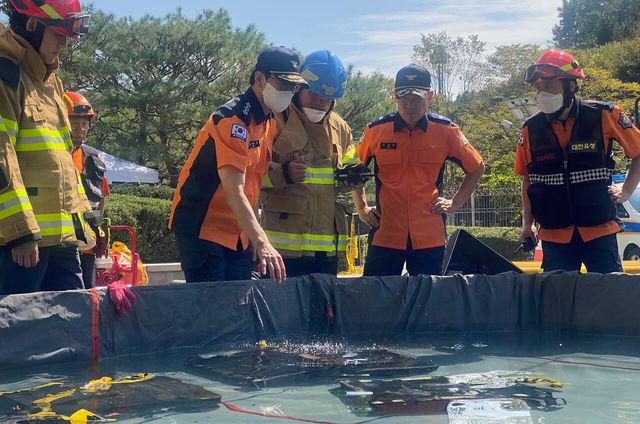 김승룡 소방청장 직무대행이 27일 대전시 유성구 국가정보자원관리원 화재 현장에서 소화수조에 담긴 불에 탄 리튬이온 배터리를 살펴보고 있다. [사진제공=소방청]