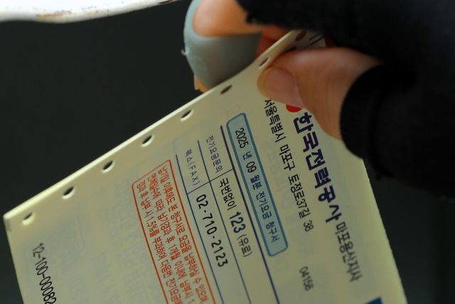 서울 시내 한 주택가에 관계자가 전기요금고지서를 배달하고 있다. [사진=뉴시스]