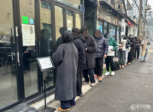 15일 서울 시내 한 디저트 카페 앞에서 매장 직원이 두바이쫀득쿠키를 구매하려는 고객들에게 번호표를 나눠주고 있다.&nbsp;ⓒ투데이신문