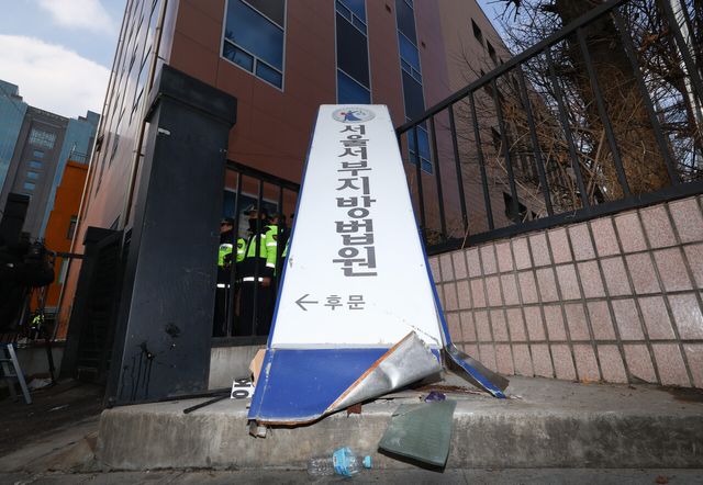 지난해 1월 19일 윤석열 대통령 지지자들의 폭동 사태가 발생한 서울 마포구 서울서부지방법원의 현판이 파손돼 있는 모습. [사진제공=뉴시스]<br>