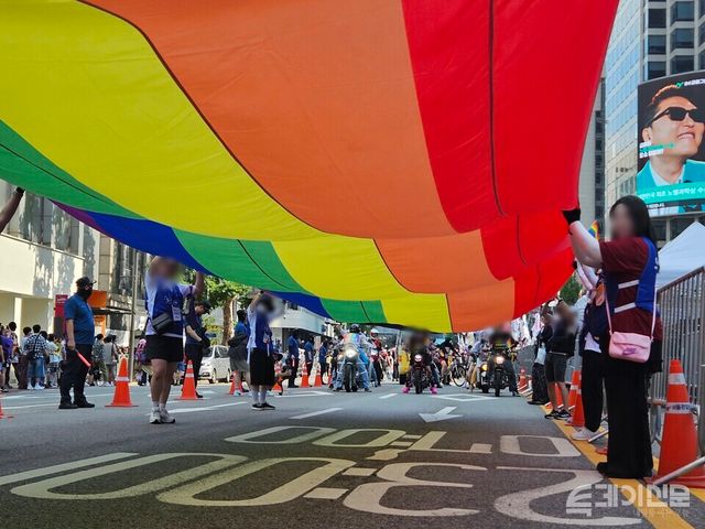 지난해 6월 14일 오후&nbsp;남대문로 및 우정국로 일대에서 열린 2025 서울 퀴어퍼레이드에서 운영진이 무지개색 천을 나눠 들고 행진하고 있다. ⓒ투데이신문