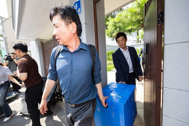 12·3 비상계엄 관련 내란·외환 혐의를 수사하는 내란 특검 관계자들이 지난해 7월 24일 오후 서울 종로구 한덕수 전 국무총리 자택에서 압수수색을 마친 뒤 압수품을 들고 나서고 있다. [사진제공=뉴시스]