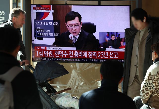 한덕수 전 국무총리의 내란 우두머리 방조, 내란 중요임무 종사 혐의 사건 1심 선고 재판이 열린 21일 오후 서울역 대합실에서 시민들이 한 전 총리의 1심 징역 23년 선고 관련 뉴스를 시청하고 있다. [사진제공=뉴시스]