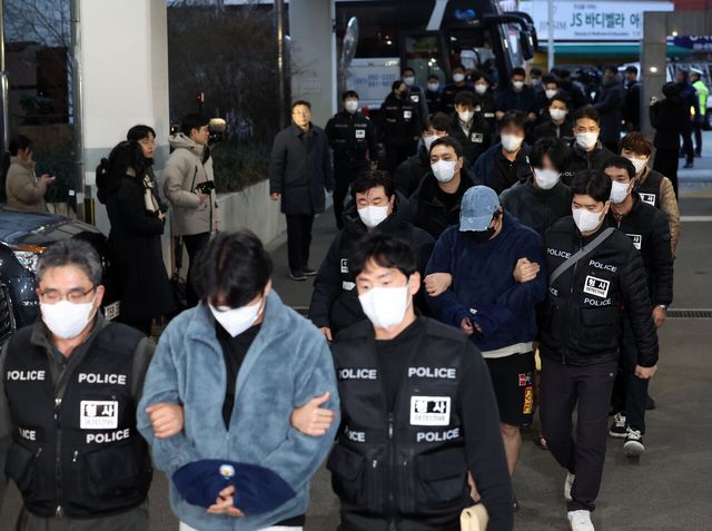 지난 23일 캄보디아 범죄단체에 가담한 혐의를 받아 강제송환된 한국인 조직원 일부가 부산 동래구 동래경찰서로 압송되고 있다. [사진제공=뉴시스]