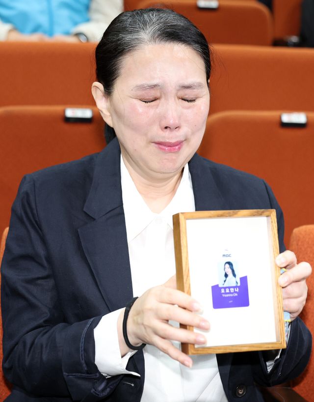 고(故) 오요안나씨 어머니 장연미씨가 지난해 1월 15일 오전 서울 마포구 MBC에서 열린 고 오요안나 1주기 관련 대국민 기자회견에서 고인의 명예사원증을 들고 있다. [사진제공=뉴시스]<br>
