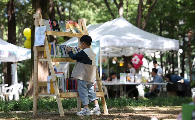 2025년 9월 서울 강남구 도산공원에서 개최된 가족숲속도서관 행사의 야외 팝업 도서관에서 한 어린이가 책을 고르고 있다. [사진제공=뉴시스]