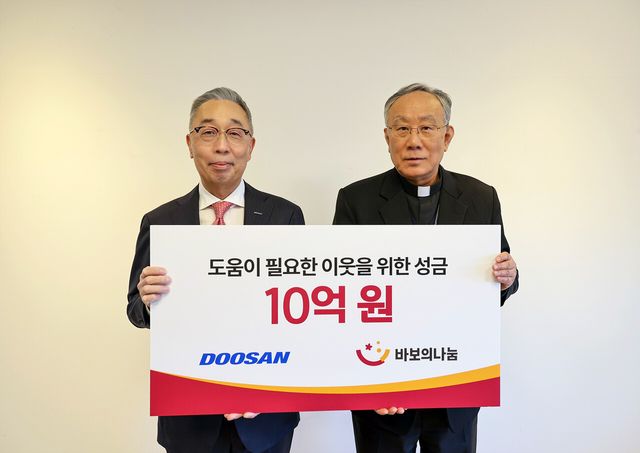 두산그룹 박지원 부회장(왼쪽)과 재단법인 바보의 나눔 구요비 이사장이 지난 3일 서울 명동성당에서 열린 성금 전달식에서 기념촬영을 하고 있다. [사진=두산그룹]