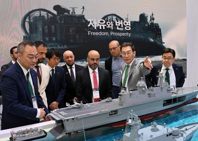 HJ중공업 유상철 대표(오른쪽 두 번째)가 2025년 부산 벡스코에서 열린 국제해양방위산업전(MADEX)에서 해외 바이어들에게 설명하는 모습. [사진=HJ중공업]