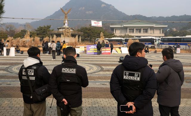 이재명 대통령이 청와대에서 집무를 시작한 지난해 12월 29일 서울 종로구 청와대 인근에서 시민사회단체들이 집회를 진행하고 있는 가운데, 경찰들이 업무를 보고 있다. [사진제공=뉴시스]<br>