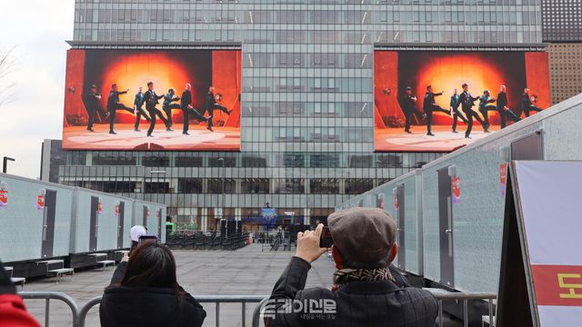 광화문광장 인근 건물에서 BTS 광고가 나오는 것을 보고 사진을 찍는 관광객들 ©투데이신문<br>