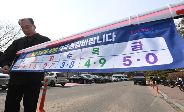 24일 경기 군포시청 주차장 입구에서 직원들이 오는 25일부터 시행 예정인 차량 5부제를 앞두고 관련 안내문을 게시하고 있다. [사진제공=뉴시스]<br>