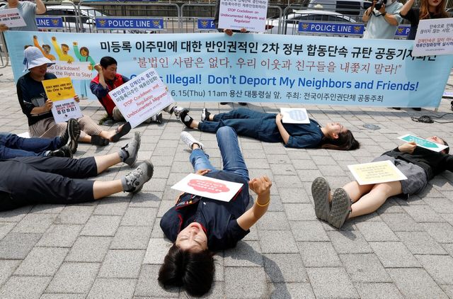 전국이주인권단체 회원들이 2023년 6월 서울 대통령실 앞에서 미등록 이주민 반인권적 2차 정부 합동단속 규탄 기자회견을 마친 뒤 다이 인 퍼포먼스를 하고 있다. [사진제공=뉴시스]