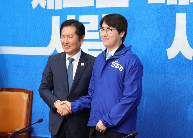 하정우 전 청와대 AI미래기획수석이 29일 오전 서울 여의도 국회에서 열린 더불어민주당 2차 인재영입식에서 정청래 당대표로 부터 당점퍼를 받아 입고 기념촬영을 하고 있다. [사진제공=뉴시스]