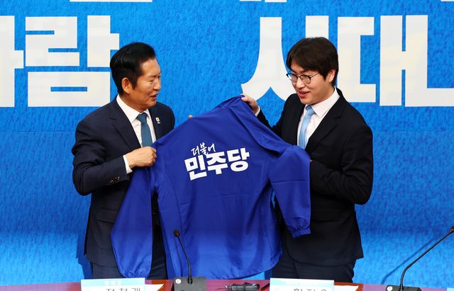 하정우 전 청와대 AI 미래기획수석비서관이 29일 오전 서울 여의도 국회에서 열린 더불어민주당 인재영입식에서 정청래 대표와 당 점퍼를 들고 있다. [사진제공=뉴시스]