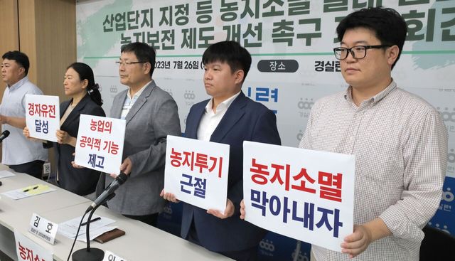 경제정의실천시민연합 활동가들이 2023년 7월 26일 오전 서울 종로구 경제정의실천시민연합에서 열린 ‘산업단지 지정 등 농지소멸 실태 발표 및 농지보전 제도 개선 촉구 기자회견’에서 피켓을 들어보이고 있다. [사진제공=뉴시스]