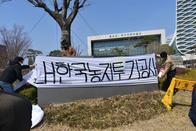 전농부경연맹이 2021년 3월 8일 경남 진주 한국토지주택공사 본사에서 농지 투기 관련 기자회견을 열고 프랭카드를 게시하고 있다. [사진제공=뉴시스]