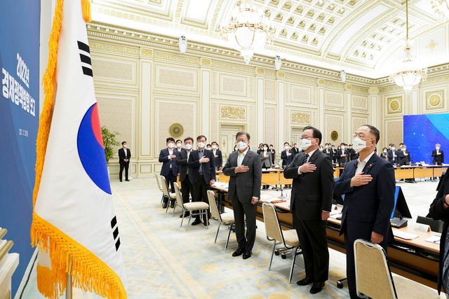 문재인 전 대통령이 지난 2021년 12월 20일 청와대 영빈관에서 열린 ‘2022년도 경제정책방향’ 보고 확대 국민경제자문회의에서 김부겸 국무총리, 홍남기 경제부총리 겸 기획재정부 장관, 이근 국민경제자문회의 부의장을 비롯한 참석자들과 국민의례를 하고 있다. [사진제공=뉴시스]