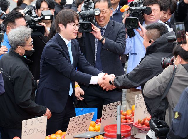 하정우 전 청와대 AI미래기획수석이 4월 29일 부산 북구 구포시장에서 상인과 인사한 뒤 과일을 구입하고 있다. 하 전 수석은 전재수 더불어민주당 부산시장 후보의 지역구인 부산 북갑 보궐선거에 출마할 예정이다. [사진제공=뉴시스]