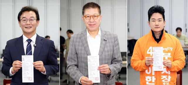 제9회 전국동시지방선거 후보 등록 첫날인 14일 부산 연제구 부산시선거관리위원회에서 전재수(왼쪽부터) 더불어민주당 부산시장 후보, 박형준 국민의힘 부산시장 후보, 정이한 개혁신당 부산시장 후보가 후보등록 절차를 마무리한 뒤 접수증을 들어보이고 있다. [사진제공=뉴시스]