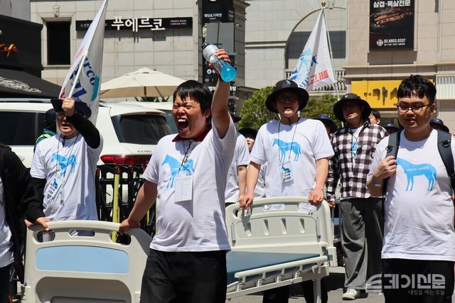 매드프라이드 페스티벌 참가자가 22일 서울 여의도 국회의사당역 일대에서 침대 밀기 퍼포먼스를 진행하며 구호를 소리치고 있다. ⓒ투데이신문<br>