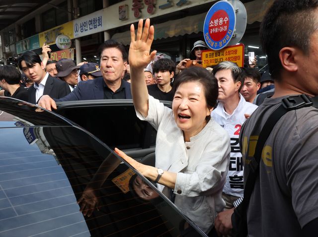 박근혜 전 대통령이 25일 오후 충남 공주시 산성시장을 찾아 제9회 전국동시지방선거 국민의힘 후보들과 함께 시민들에게 손을 흔들며 인사하고 있는 모습. [사진제공=뉴시스]
