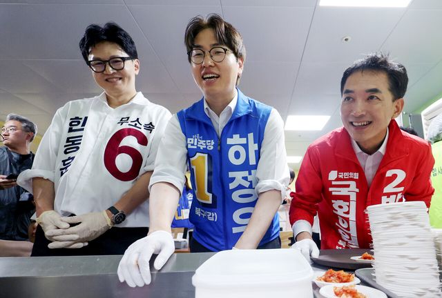 제9회 전국동시지방선거 및 국회의원 재·보궐선거의 공식 선거운동이 시작된 21일 부산 북구갑 국회의원 보궐선거 국민의힘 박민식(오른쪽부터), 더불어민주당 하정우, 무소속 한동훈 후보가 부산 북구 남산정복지관에서 열린 콩국수 나눔행사에서 콩국수를 기다리고 있다. [사진제공=뉴시스]