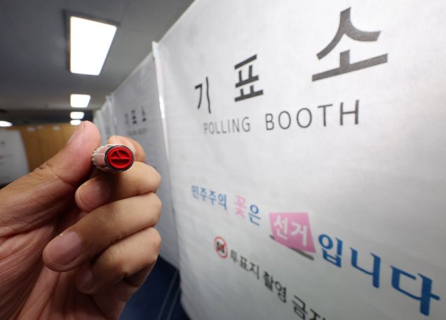 제9회 전국동시지방선거 사전투표를 하루 앞둔 28일 오후 서울 서대문구 신촌동 사전투표소에서 직원이 기표봉을 들어보이고 있다. [사진제공=뉴시스]<br>
