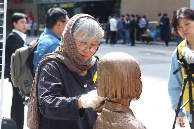 6일 오후 김서경 작가가 스카프를 둘러쓰고 평화의 소녀상의 훼손된 부분을 살펴보고 있다.&nbsp;ⓒ투데이신문<br>