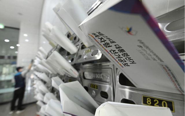 지난해 5월 18일 경기 수원 소재 한 건물에서 우체국 집배원이 제21대 대통령선거 안내문과 선거공보물을 우편함에 넣고 있다. [사진제공=뉴시스]