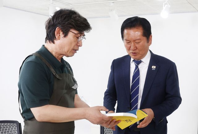 정청래 더불어민주당 대표가 지난 4월 24일 오후 서울 성동구 언더스탠드에비뉴에서 열린 청각장애인 수제화 브랜드 ‘아지오’ 매장 오픈 행사에서 유시민 작가로부터 책 ‘사랑이 있으니 살아집디다’를 전달받고 있다. [사진제공=뉴시스]<br>
