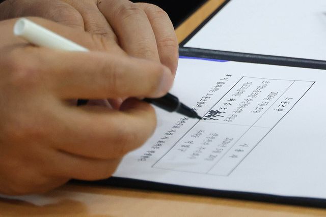 삼성전자 DS 여명구 피플팀장이 지난달 20일 오후 경기 수원시 장안구 경기지방고용노동청에서 열린 삼성전자 노사교섭 결과 브리핑에서 합의안에 서명을 하고 있다. [사진제공=뉴시스]