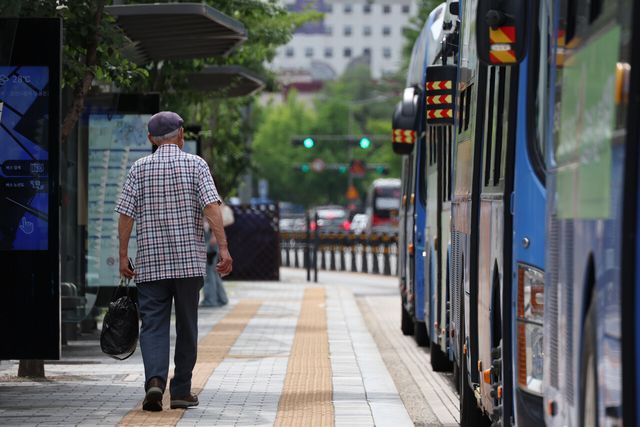 지난 24일 서울 광화문 인근 한 버스정류장에서 한 어르신이 걸음을 옮기고 있다. [사진제공=뉴시스]