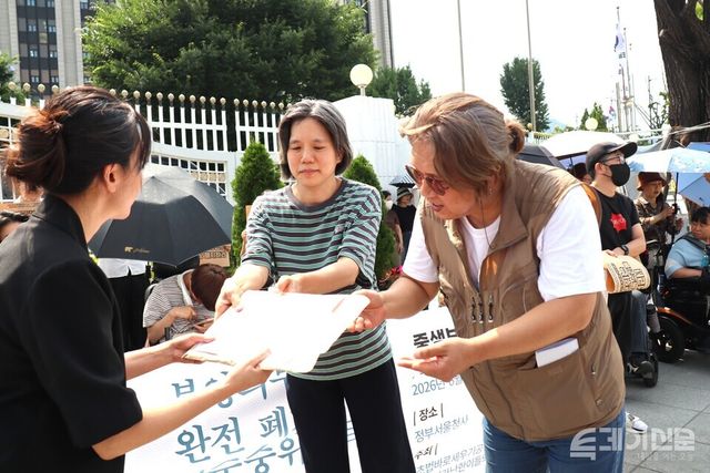 시민사회단체 관계자들이 29일 서울 정부종합청사 앞에서 복지부 관계자에게 기준중위소득 현실화 요구안을 전달하고 있다.&nbsp;ⓒ투데이신문<br>