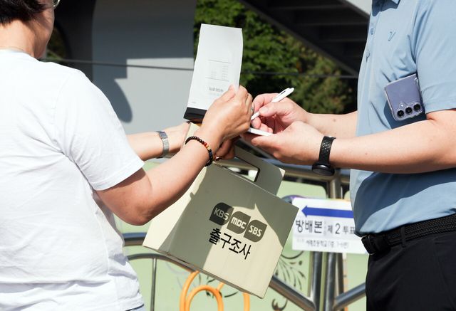 제9회 전국동시지방선거 선거일인 3일 서울 서초구 서래초등학교에 차려진 방배본동제2투표소에서 출구조사원들이 유권자들의 설문을 받고 있다. [사진제공=뉴시스]