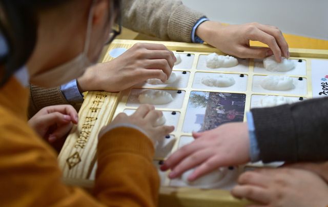 시각장애인 특수학교인 대구 남구 대구광명학교 졸업식이 진행됐던 2023년 1월 13일 졸업생들이 3D 프린터로 제작한 입체 졸업앨범에 실린 친구 얼굴을 손으로 만져보고 있다. [사진제공=뉴시스]