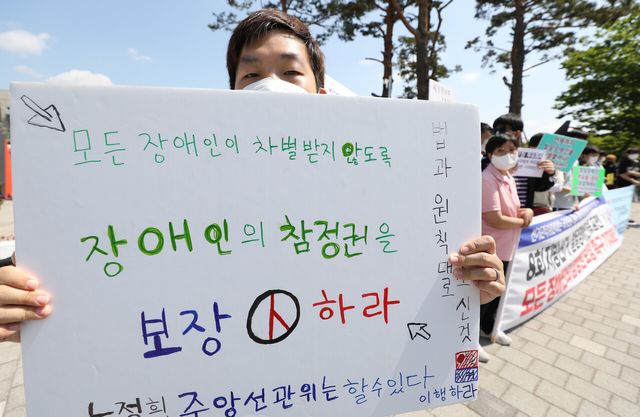 제8회 전국동시지방선거 사전투표가 진행된 2022년 5월 27일 서울 용산구 전쟁기념관 6.25 상징탑 앞에서 장애인차별금지추진연대 등이 발달장애인을 포함한 모든 장애인의 참정권 보장을 촉구하고 있다. [사진제공=뉴시스]