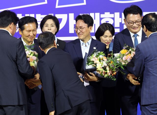 더불어민주당 8·17 전당대회 대표 경선에 진출한 정청래(왼쪽부터), 김민석, 송영길 후보가 23일 여의도 국회의원회관에서 열린 당대표·최고위원 선출을 위한 예비경선 결과발표에서 꽃다발을 들고 축하를 받고 있다. [사진제공=뉴시스]