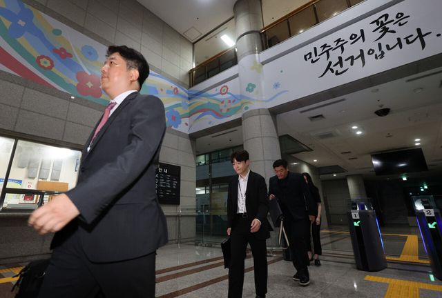 검경 합동수사본부 직원들이 지난 23일 경기 과천 중앙선거관리위원회에서 압수수색을 마친 뒤 걸음을 옮기고 있다. [사진제공=뉴시스]