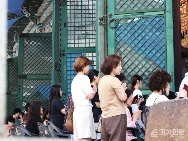 대웅전 밖에서도 사람들이 손을 모으고 기도에 참여하고 있다. ⓒ투데이신문