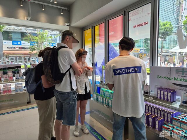 서울 성수동의 한 올리브영 매장을 찾은 외국인 관광객이 선케어 제품에 대한 설명을 듣고 있다. ⓒ투데이신문