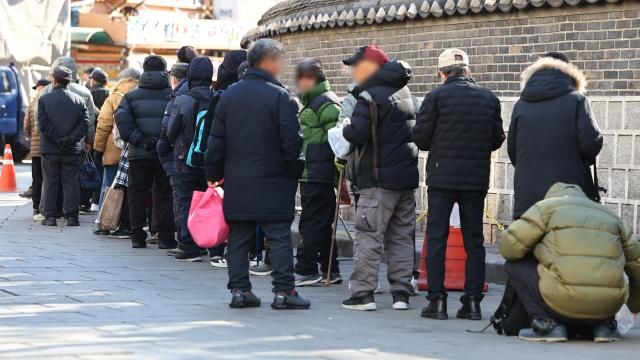 上月24日，在首尔钟路区爱心助老供餐点，老人们在排队取餐。【图片来源 韩联社】