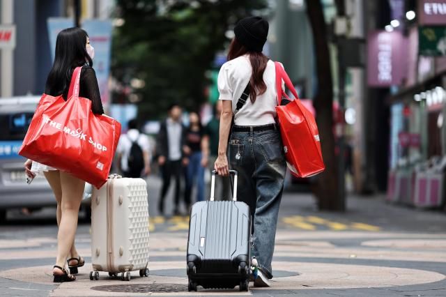 26日，明洞街头提着手提箱的外籍游客。【图片来源 韩联社】
