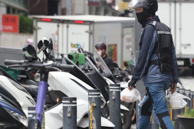 上月17日，在首尔江南配送外卖的骑手。【图片提供 韩联社】