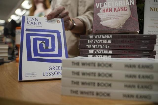 A book store employee handles books by the South Korean writer Han Kang in London on Oct 10 2024 AP-Yonhap
