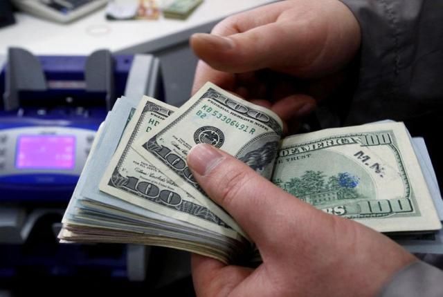 A money changer counts US dollar bills at a currency exchange office in central Istanbul in this file photo from April 2015 Reuters-Yonhap