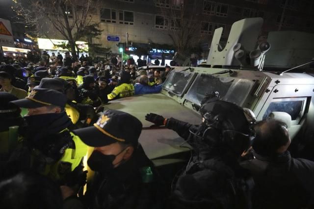 Military vehicle is escorted by police officers as people try to block outside of the National Assembly in Seoul on Dec 4 2024 AP-Yonhap