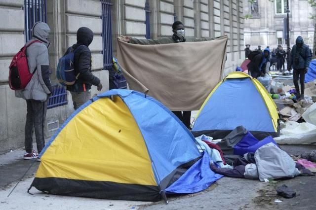 Migrants pack their belongings while being evicted from a makeshift camp in Paris on April 30 2024 Similar operations are carried out by the police authorities on a daily basis in the months leading to the Olympics AP-Yonhap