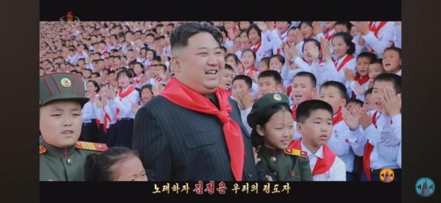North Koreas leader Kim Jong-un smiles at the music video for Friendly Father the countrys new propaganda song The picture was captured from YouTube